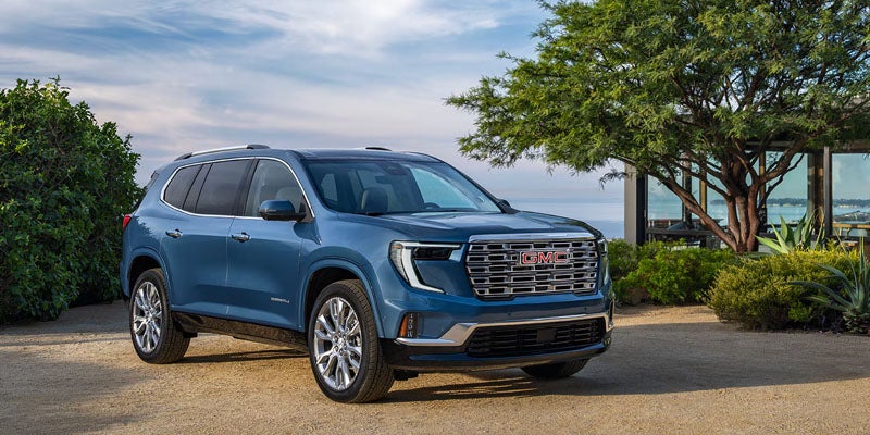GMC Acadia SUV parked near coastal landscape with trees