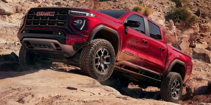GMC Canyon AT4 pickup truck climbing rocky off-road terrain